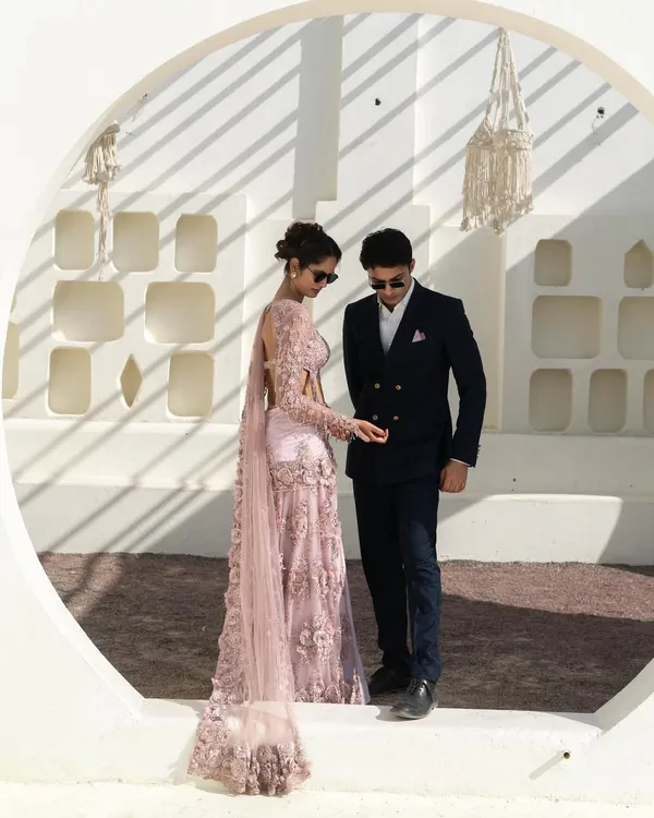 We specialize in making you and your partner look perfectly coordinated. This stunning pre-wedding shoot features our intricately detailed lilac saree-lehenga paired with a sharp navy double-breasted suit.