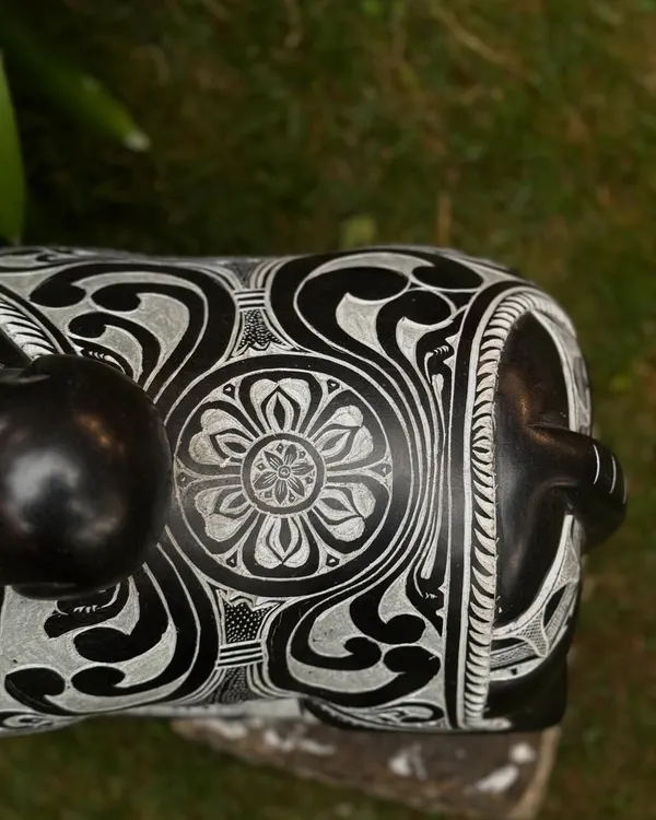 A close-up of a seated Nandi statue, showcasing the intricate floral and geometric patterns carved into the stone by our artisans.