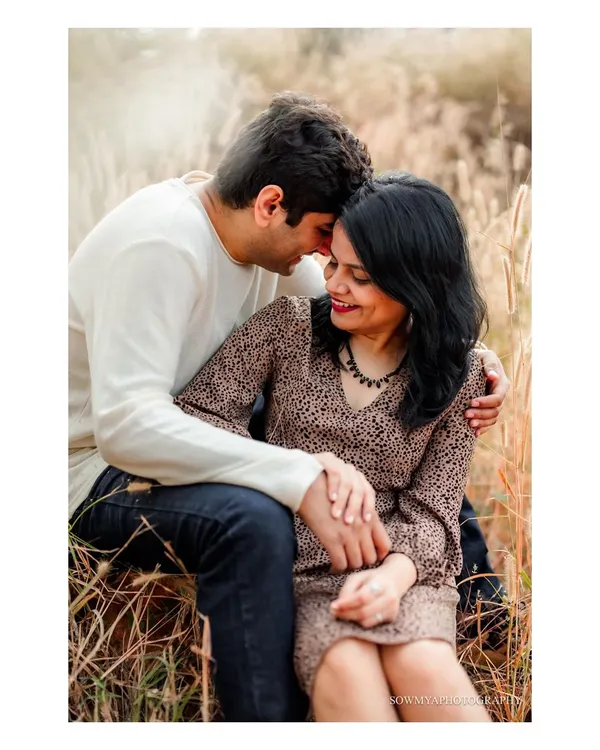 A tender moment shared between a couple, nestled in a field of tall, golden grass. Outdoor sessions like this allow for beautifully natural and romantic portraits.