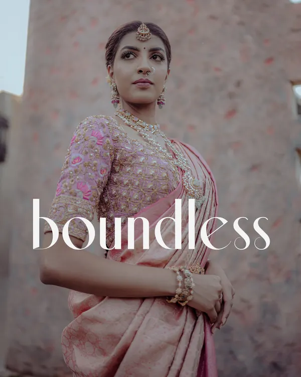 A stunning, magazine-style portrait of a South Indian bride in a pink silk saree. The low-angle shot and her confident pose create a powerful and elegant image.