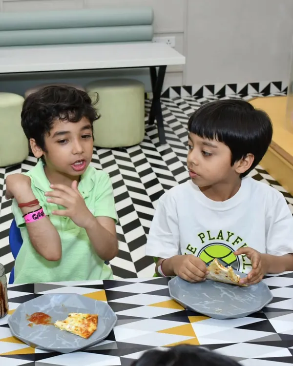 Fueling up for more fun! Here, two boys are enjoying some pizza and a chat during a party. I make sure the dining area is comfortable and the food is exactly what kids love to eat.
