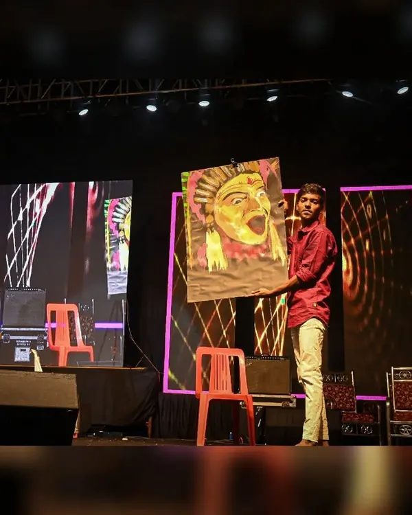 Holding up the completed Kantara speed painting on stage. The energy of the crowd fuels the final, dramatic reveal of the artwork.