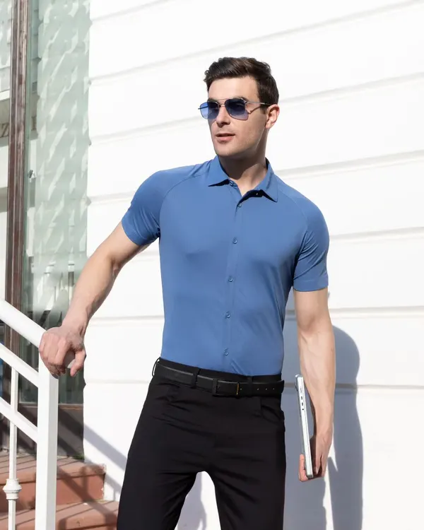 A male model wearing a steel blue Harfunlife shirt, shot outdoors in bright sunlight. The image highlights the shirt's fit and color, while the modern setting gives it a professional and stylish context.