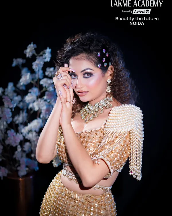 A stunning glam makeup look perfect for any party. This shot highlights the sharp winged eyeliner, shimmering eyeshadow, and intricate pearl-and-gold outfit, a complete look our students learn to create.