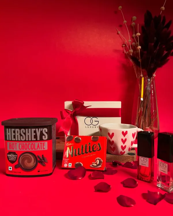 The 'Cozy Delights' hamper is perfect for a romantic night in. It features Hershey's hot chocolate, a heart-themed mug, Nutties, and a set of four luxury perfumes.