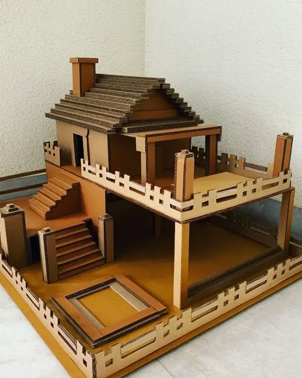 Our modern villa dollhouse kit is a builder's delight. It includes two floors, outdoor patio space, detailed railings, and a staircase, all made from sturdy, slot-together cardboard.