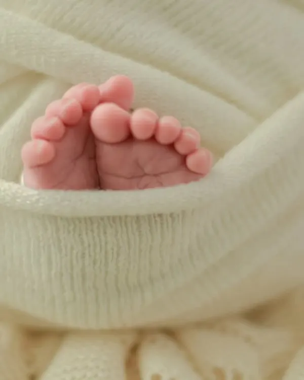 The tiniest details hold the biggest love. A close-up of your newborn's perfect little feet, nestled in a soft wrap, is a simple yet profound reminder of how small they once were. These detail shots are a cherished part of every newborn session.