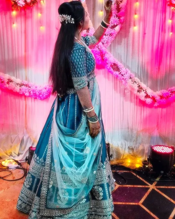 A happy client at her event, looking beautiful in a teal blue lehenga with silver embroidery. It's wonderful to see my outfits be a part of such special moments.