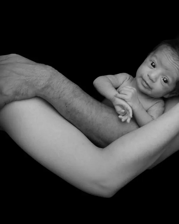 This is one of my signature newborn portraits. I use a black and white fine art style to emphasize the profound connection between parents and their new baby, creating a timeless piece of art. As a certified newborn photographer, I ensure your baby is posed safely and comfortably throughout the session.