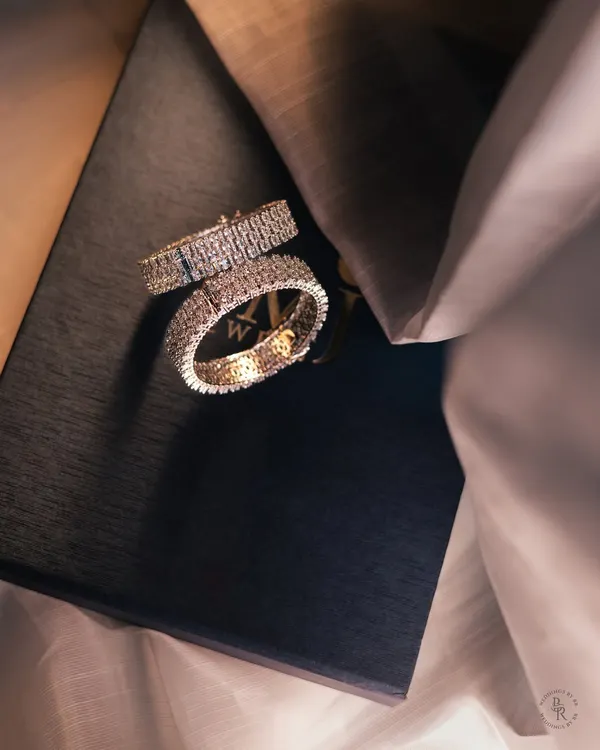 A luxurious shot of the couple's diamond-studded wedding bands, symbolizing their promise to reign together in love.