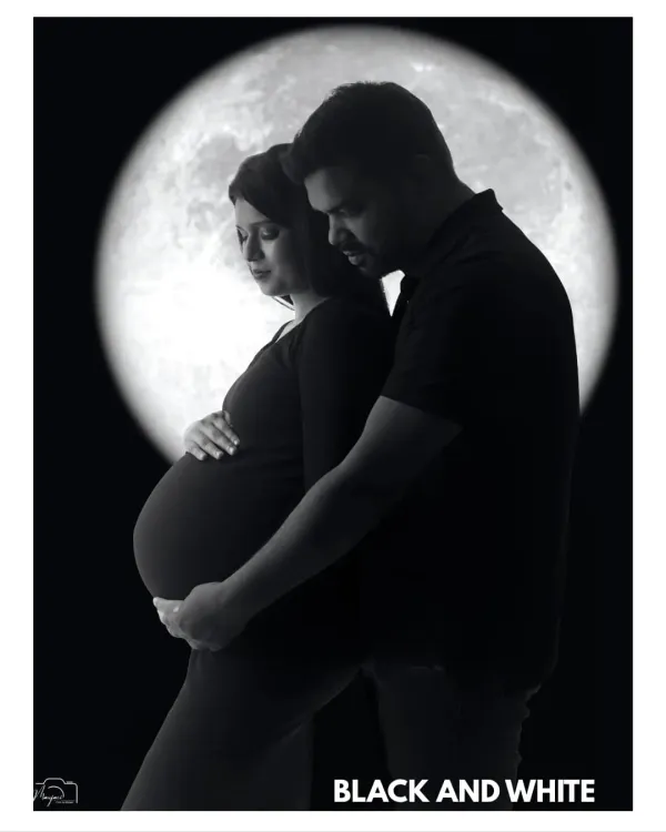 A classic black and white silhouette of a couple against a full moon, their forms creating a beautiful and timeless image of love and anticipation.