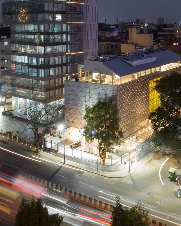 This is the Museum of Art & Photography (MAP) in Bengaluru, a cultural landmark we designed to be a 'tanki' or container for art. The building's stainless steel facade reflects the city's energy, creating a dynamic presence in the urban landscape, especially as dusk settles and the structure glows from within.