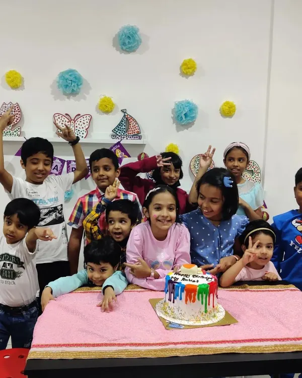Pure party joy! A happy group gathers for the birthday cake moment after creating their own personalized desk calendars.