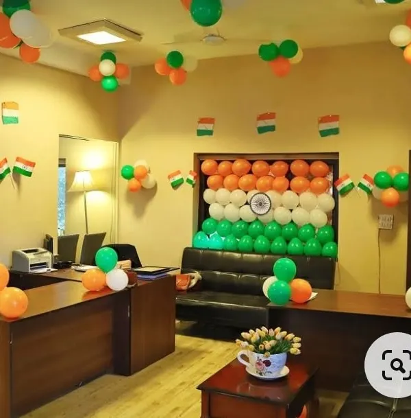 Here is a full office decoration I did for Independence Day. The main feature is a large backdrop of the Indian flag made entirely of saffron, white, and green balloons, complete with a printed Ashoka Chakra in the center. I also added smaller balloon clusters and flag bunting throughout the room.