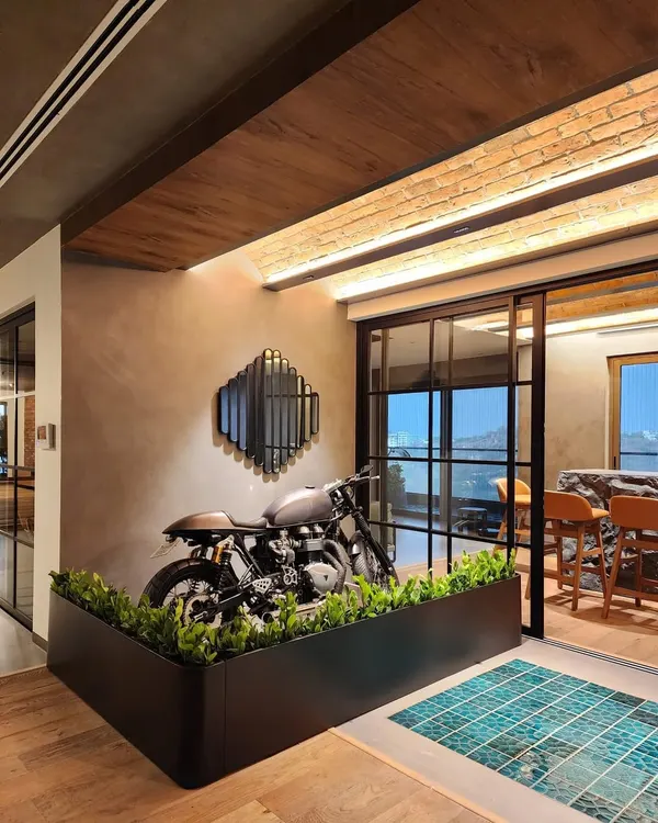 This project in a stylish Hyderabad home is one of our all-time favorites. The clients, both bikers, needed a way to protect their gorgeous Triumph motorcycle from their toddler. We designed and built this custom living partition that acts as a beautiful, green barrier while turning the bike into a stunning decor piece.
