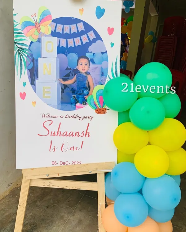 A personalized welcome sign for a first birthday, featuring a photo of the birthday boy and theme elements.