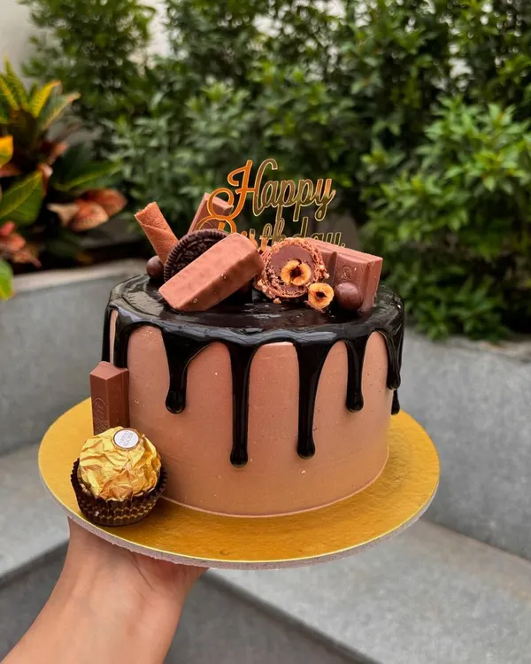A chocolate lover's dream. This chocolate drip cake is overloaded with treats like Ferrero Rocher, KitKat, and Oreo cookies.