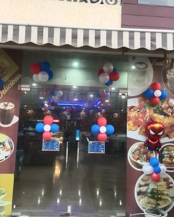 The entrance to this restaurant is decorated with red, white, and blue balloon clusters and a Spiderman foil balloon to welcome guests to a themed party.