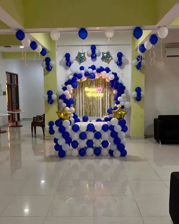 A classic blue and white balloon decoration for a cake table, featuring a half-arch and star foil balloons.