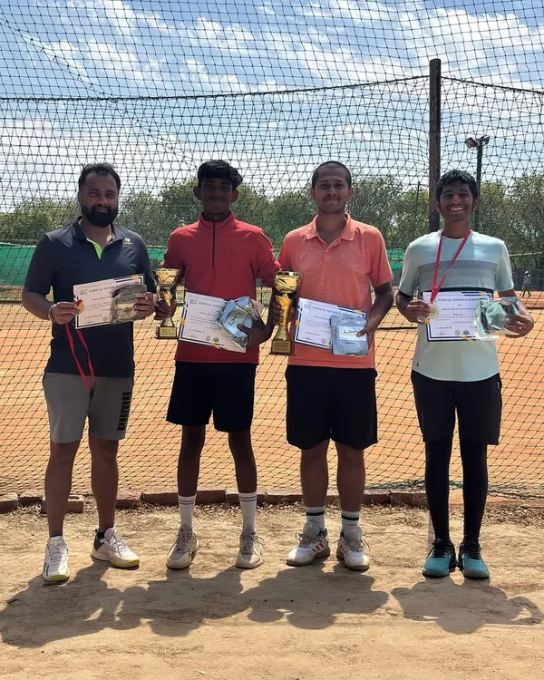 The winner, runner-up, and semi-finalists of our monthly prize money tournament. This group photo shows the top four competitors with their trophies, medals, and certificates on the clay court.