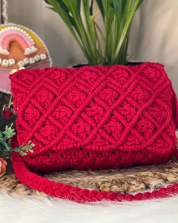 This stunning, vibrant red sling bag is a true showstopper. The intricate diamond knotting on the flap and the sturdy, braided strap make it both a beautiful and practical accessory for any occasion.