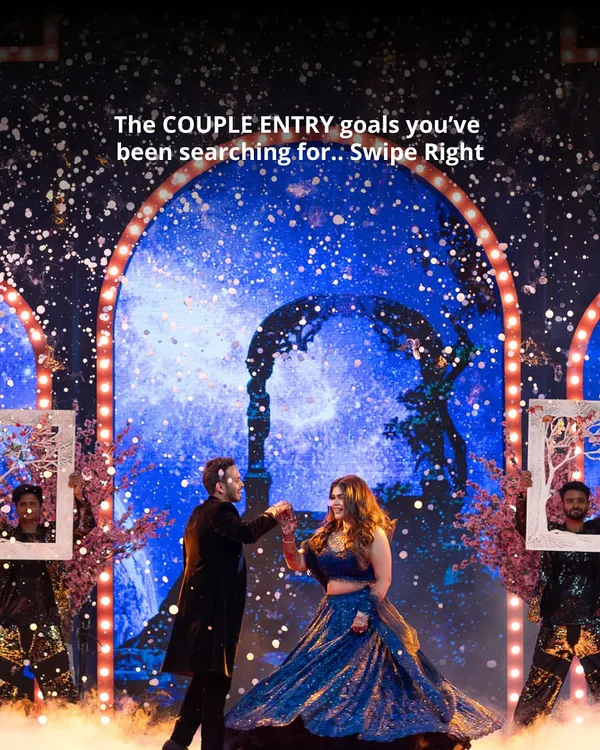 A couple's Sangeet entry that feels like a scene from a movie. The starry night backdrop and performers with framed portraits create a magical and personalized welcome.