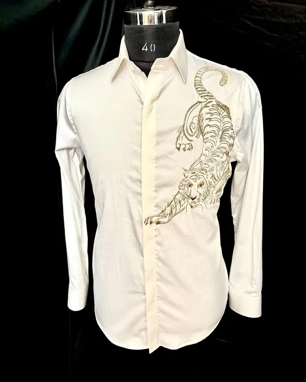 The 'White Tiger' shirt. I designed this piece with a powerful, crouching tiger embroidered in metallic gold thread on a crisp white shirt. The placement of the embroidery creates a sense of movement and undeniable confidence.