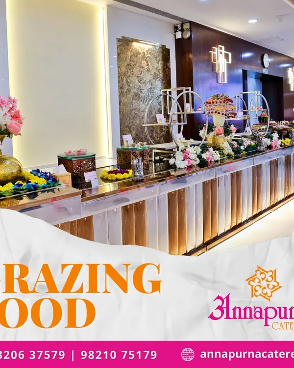 We now offer modern grazing food tables for a more interactive dining experience. This image shows an elaborate setup with a variety of appetizers and desserts, beautifully arranged with floral decorations on our stylish counters.
