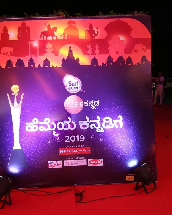 We ensure your brand is front and center. This custom backdrop for the Zee Kannada 'Hemmeya Kannadiga' awards features prominent event and sponsor branding, professionally lit for excellent photo opportunities on the red carpet.