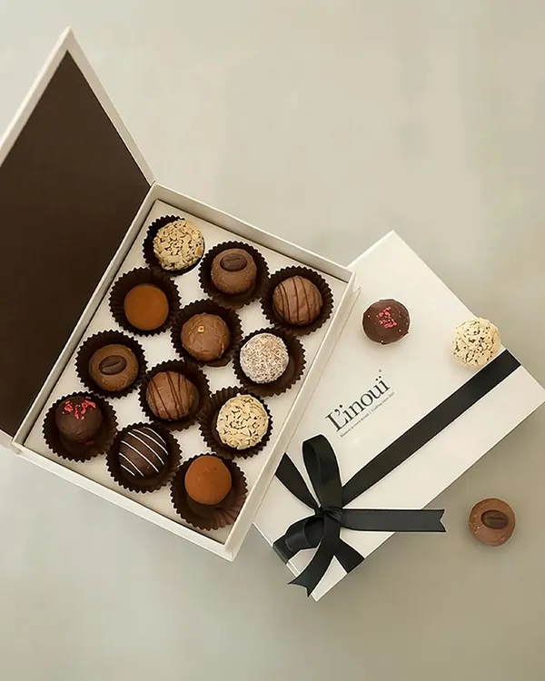 An overhead view of our assorted truffles and pralines gift box. You can see the variety of finishes, from cocoa-dusted to nut-coated and chocolate-drizzled, each promising a unique bite.