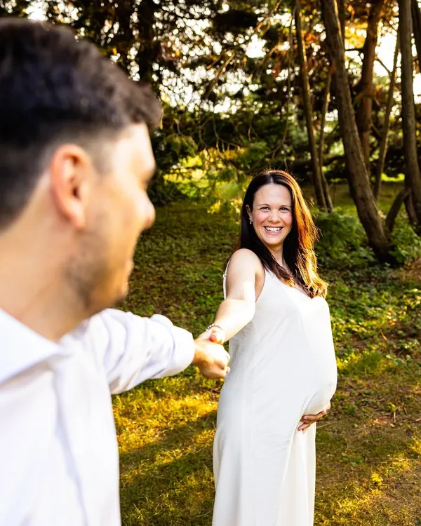 There's something so magical about golden hour. I love capturing these moments of connection, where it feels like you're in your own little world, just before your family grows by one. This couple maternity photo from a sunset session in a beautiful garden shows just that.