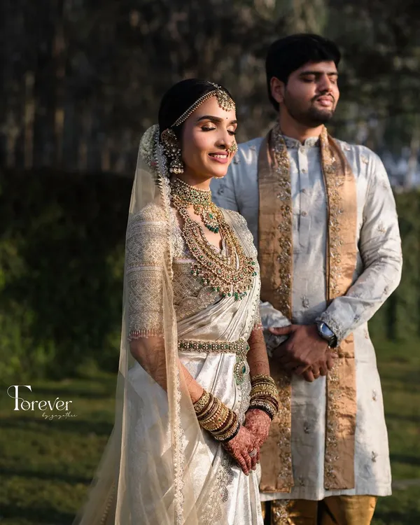 A portrait of a bride bathed in golden hour light, showcasing the radiant skin and intricate jewellery of a classic South Indian wedding look.