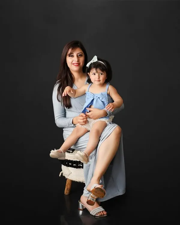 A mother's love is a precious gift. This elegant portrait of a mother and her daughter against a simple black background is a powerful and timeless image of their special bond.