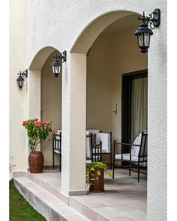 This outdoor seating deck is located across from a courtyard garden, creating a private oasis. The arched colonnade is a classic Spanish architectural feature, and the traditional black lanterns enhance the home's exterior charm.