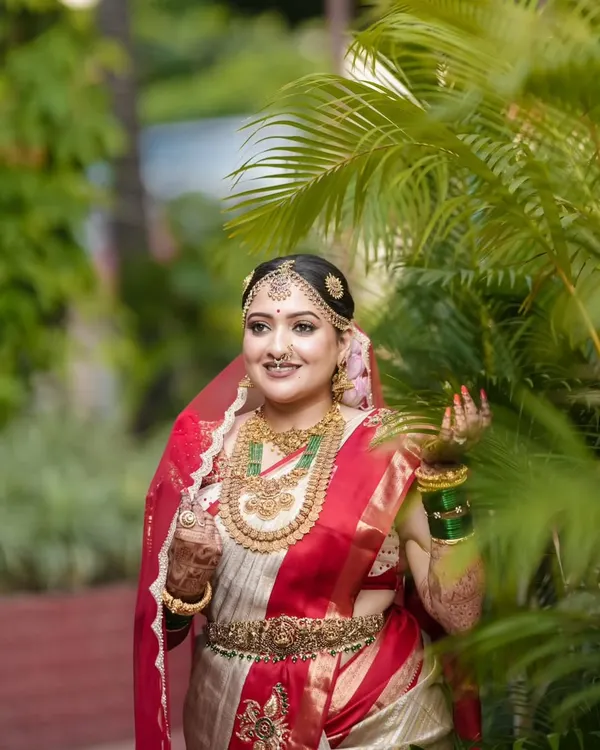 A bride's radiance is matched only by her choice of attire. We were honored to be a part of Anjana Deshpande's special day, draping her in an exclusive red and off-white Kanjivaram silk saree, a masterpiece of traditional weaving and pure zari work.