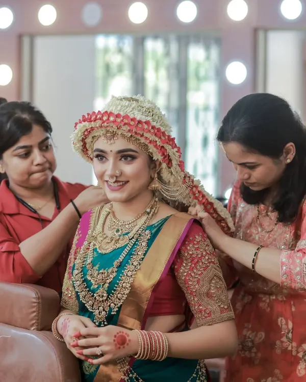 A peek into the intricate process of setting the traditional Mangalorean Sharadha Jalli. It takes a skilled team to perfect this stunning floral hairstyle.