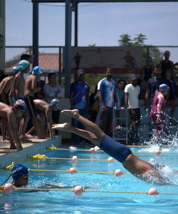 The explosive start of a swimming race during our summer camp, with young swimmers diving into action.