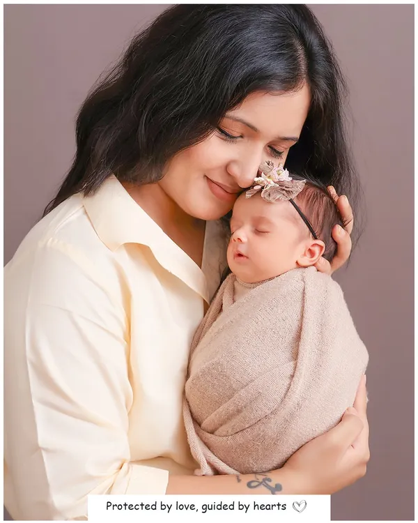 This portrait captures the quiet, protective love of a new mother. The soft lighting and the gentle embrace highlight the tender bond and the peacefulness of a sleeping newborn.