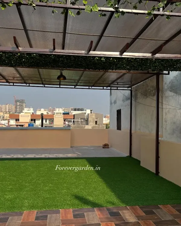 A rooftop terrace transformed with high-quality artificial grass and a green border on the pergola. This creates a usable, beautiful outdoor space that is completely maintenance-free.