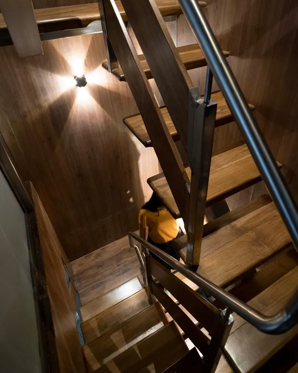 This compact, wood-clad metal staircase was custom-designed to connect two floors within a tight space, demonstrating our ability to create functional and beautiful solutions for any architectural challenge.