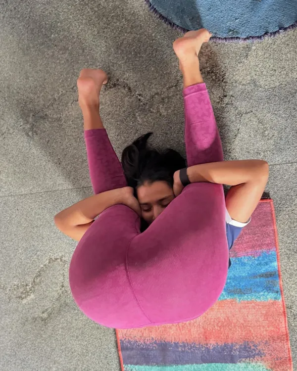My little model, Riya, demonstrating Ear Pressure Pose (Karnapidasana). This is an advanced hip-opening pose that stretches the entire back, shoulders, and hamstrings.