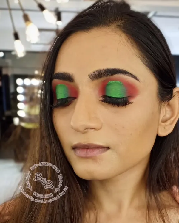 An artistic and colorful halo eye look. Using a vibrant green and red combination, this style is perfect for fashion-forward clients who want to express themselves with bold, popping colors.