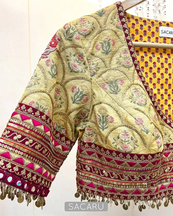 An artistic expression through fabric and embellishment. This blouse combines multiple prints and is finished with brass sequin hand-embroidered details.