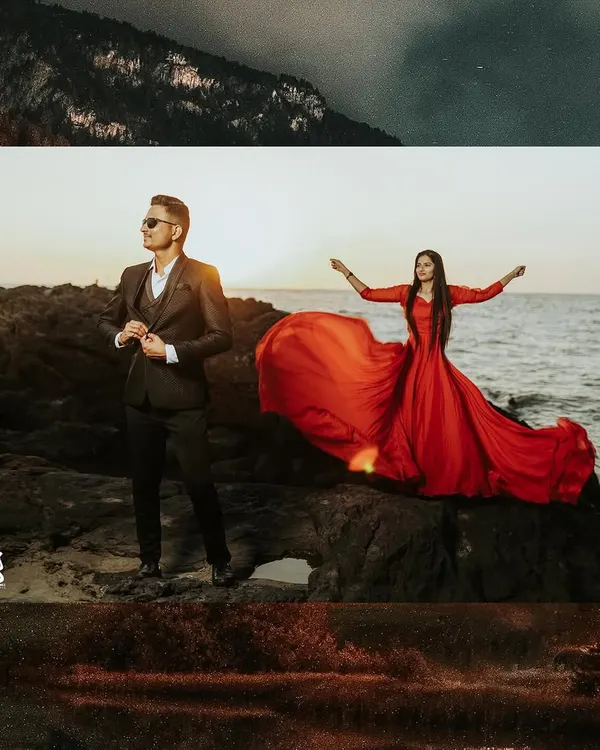 A dramatic pre-wedding portrait on the rocks by the sea. The bride's flowing red dress contrasts beautifully with the dark suit of the groom and the moody sky.