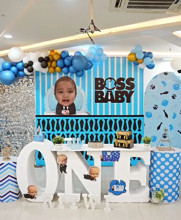 Here is a full view of our Boss Baby theme for Ritwik's first birthday. We included a custom striped backdrop, a large "ONE" table for the cake, character cutouts, and a blue, black, and white balloon arch to create the perfect corporate headquarters for the little boss.