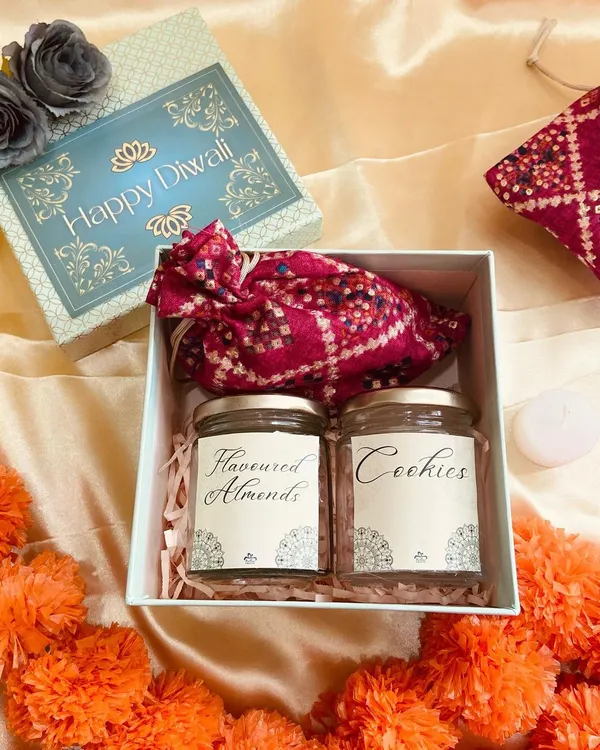 A classic Diwali hamper filled with the essence of the festival. This simple yet elegant box contains jars of flavoured almonds and cookies, and a traditional bandhani potli.