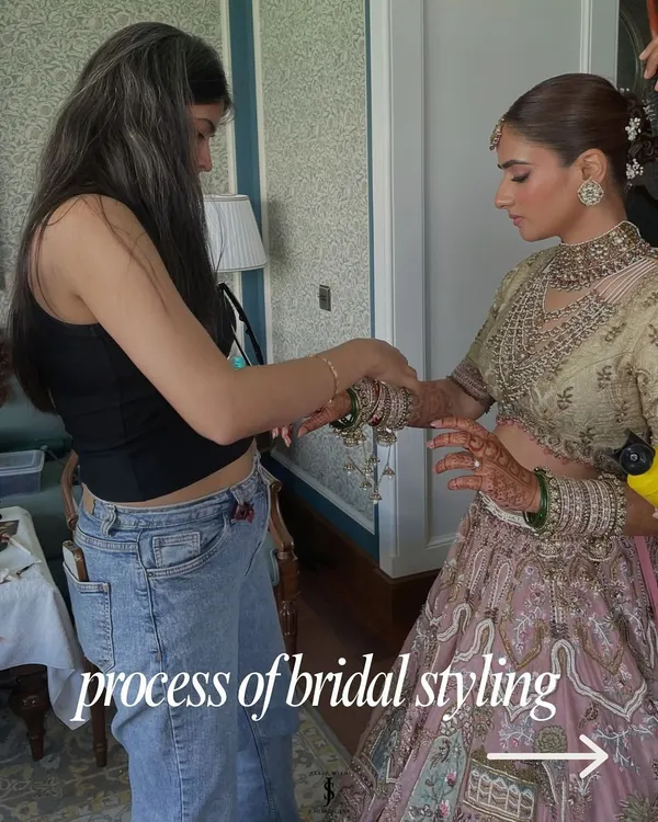 The process of bridal styling is hands-on and detailed. Here, I'm making final adjustments on-site to ensure the bride's pastel lehenga drapes perfectly for her big day.