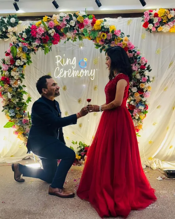 A picture-perfect proposal moment. My classic red ball gown is a stunning choice for a ring ceremony, ensuring the bride-to-be is the center of attention.