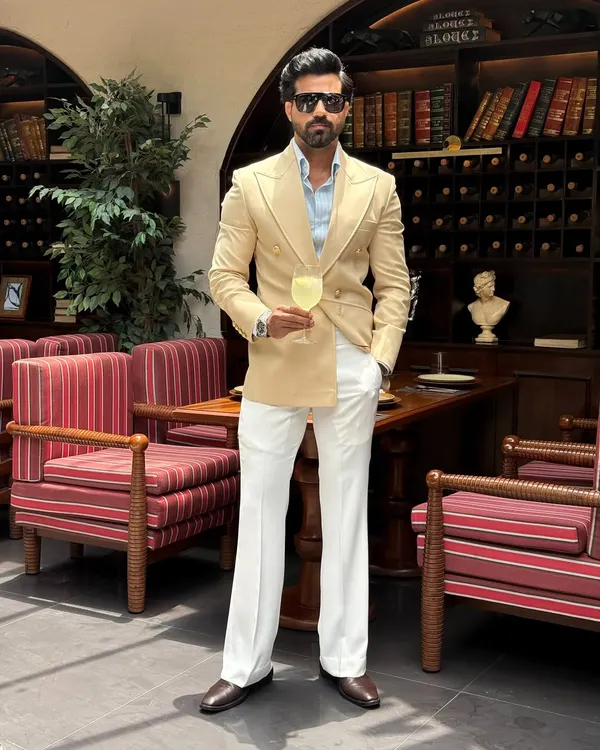 We believe a suit should be an extension of your personality. This bespoke double-breasted jacket in a refined beige, paired with crisp white trousers, is crafted for sophisticated day events and elegant soirées. It showcases a powerful silhouette and impeccable tailoring.