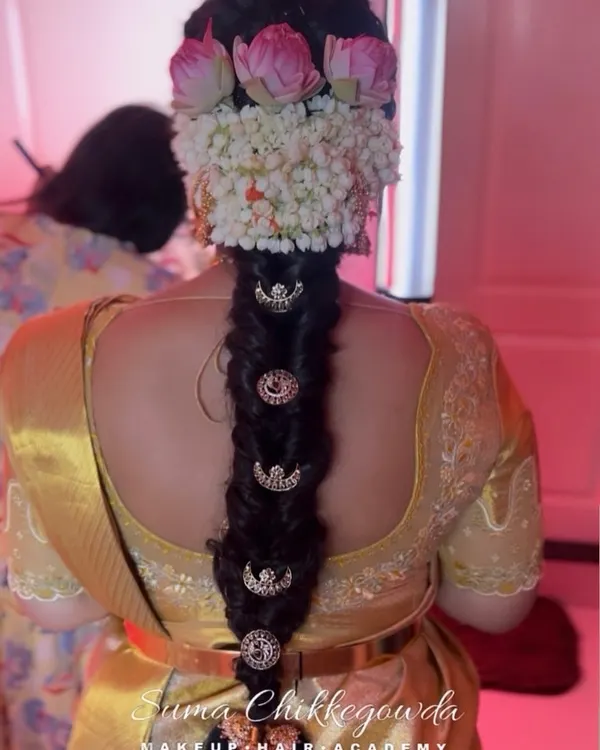 A classic South Indian bridal braid, beautifully decorated with fresh jasmine and lotus flowers, and traditional hair jewelry. This is a timeless style that we teach in our hairstyling module.